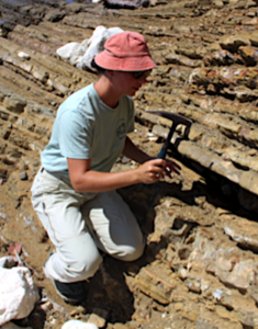 Une géologue casse un morceau de roche à l’aide d’un marteau de géologue. Une géologue casse un morceau de roche à l’aide d’un marteau de géologue.
